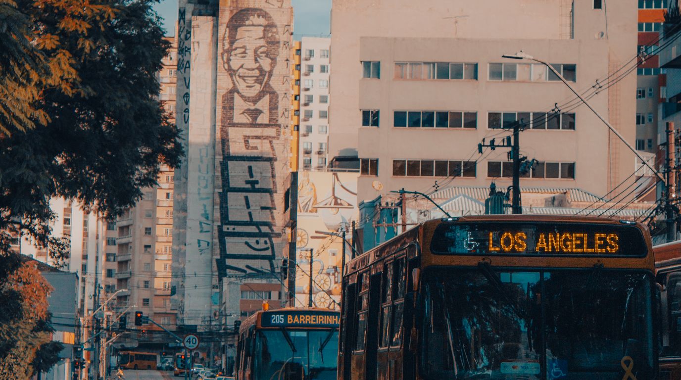 Ônibus e avenida movimentada em área urbana do Paraná.