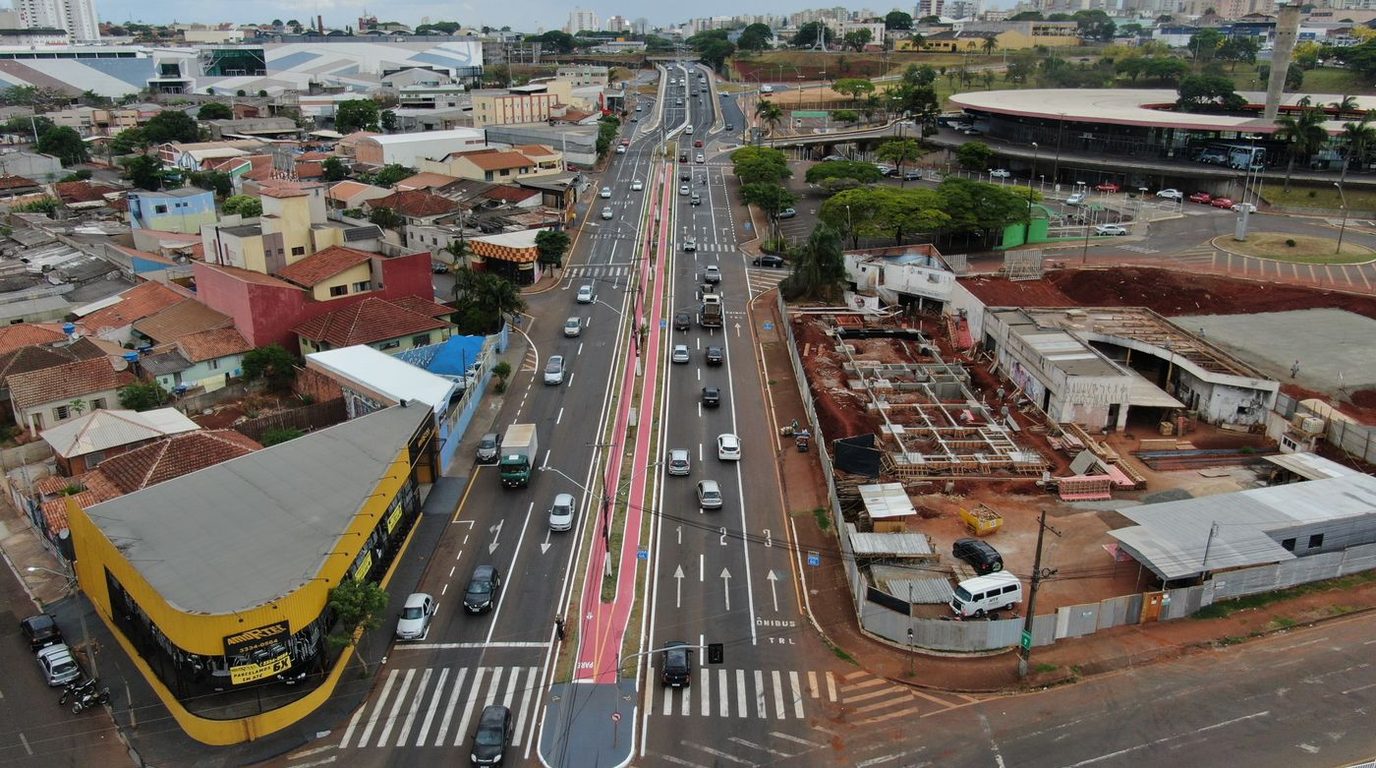 Avenida urbana movimentada com trânsito intenso.